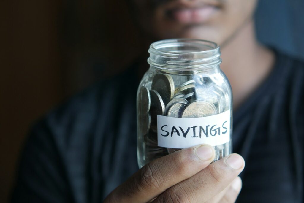 a man holding a jar with a savings label on it; 2027 HSA contribution limits