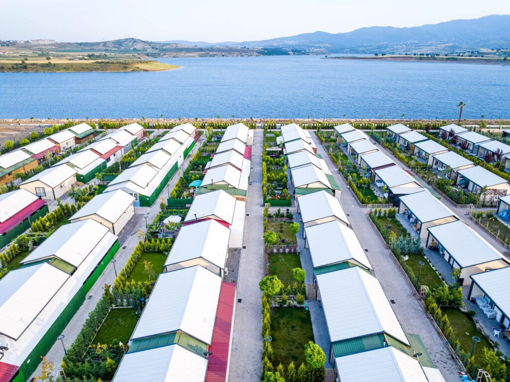 Aerial view of a picturesque village with white-roofed houses near a tranquil lake; cashflow secrets investing
