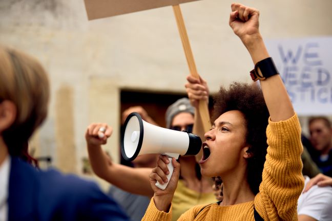 Person yelling into a megaphone at a protest