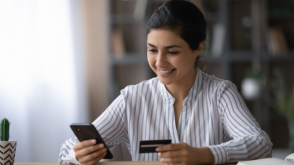 Woman using her first credit card Woman using her first credit card to make a purchase on her phone