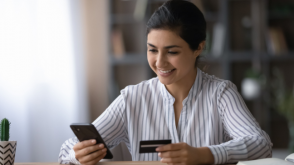 Woman using her first credit card to make a purchase on her phone