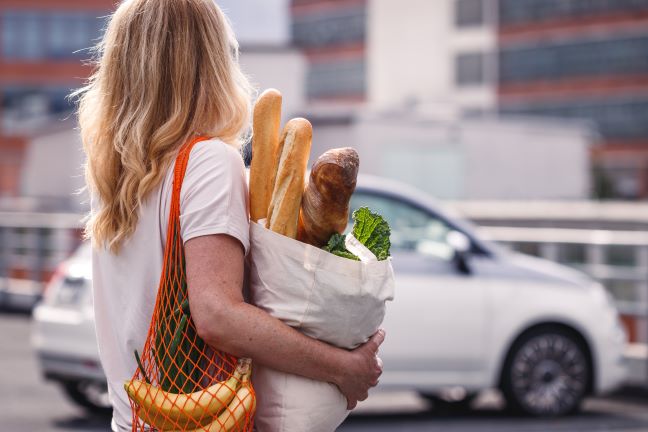 Woman carrying groceries in reusable bags