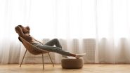 Woman relaxes in chair with arms above head and feet on stool