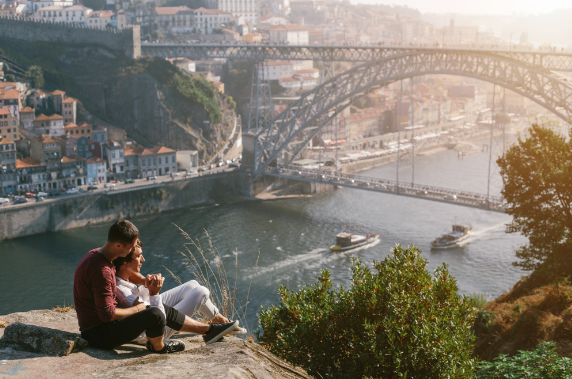 A gay couple enjoys the view of Dom Luís I Bridge in Porto, Portugal