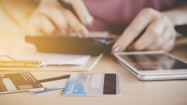 person using a calculator with a credit card in the foreground