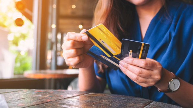 woman sorting through three credit cards