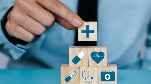 Man stacking wood blocks with medical symbols