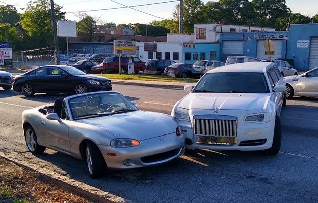A sports car and limousine in a minor accident