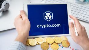 Gold coins and a tablet displaying the Crypto.com logo