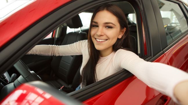 Smiling young woman sitting in a car's driver seat