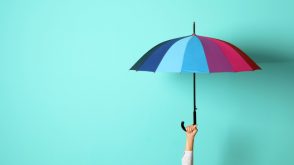 An arm holding up a multi-coloured umbrella