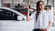 Young woman holding up car keys in front of a new car