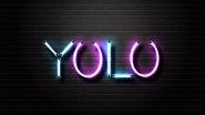 Neon sign with the word YOLO against a black brick wall