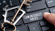 Person pressing 'low interest rates' key on keyboard