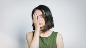 Young woman with her palm covering half her face