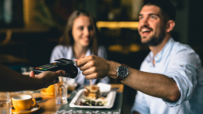Capital One SavorOne Card review Couple using a credit card to purchase food at a restaurant