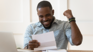 Man excited by reading a document from his lender