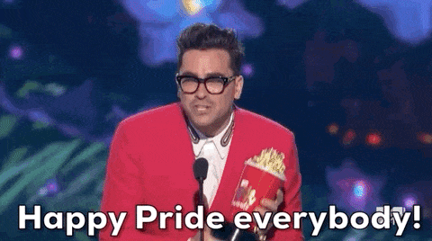 A gif of Dan Levy on stage, saying Happy Pride into a microphone