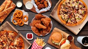 An overview photo of fast food, including burgers, pizza, chicken wings, French fries, and onion rings