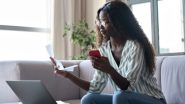 Young woman sitting on a couch, looking at her phone, a laptop, and paperwork