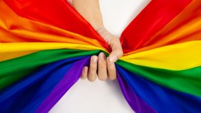 A hand grabbing a rainbow flag