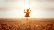 Woman on a swing, high above a city