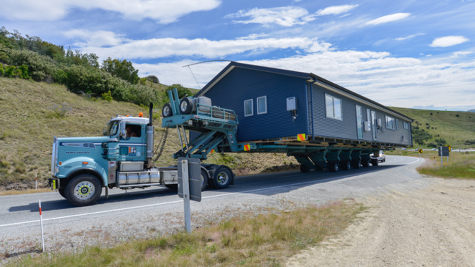 A mobile home being transported by truck