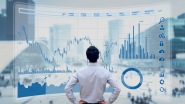 Man staring at hologram of financial graphs