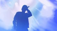 Silhouette of a male singer on stage, holding a microphone.