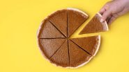 An overview shot of a pumpkin pie, cut into 8 pieces, with a hand taking one piece.