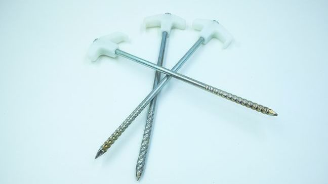 Three metal stakes piled atop one another.