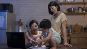 Two women play with their daughter indoors