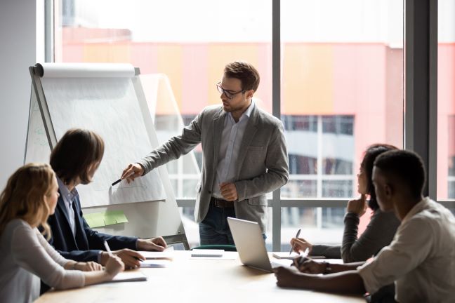 Consultant sharing ideas in a meeting with others in a company