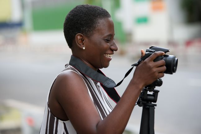 Person holding camera and smiling