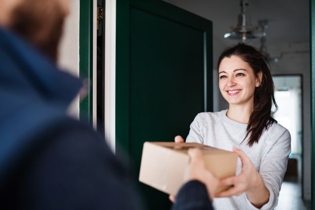 Person handing package to smiling person