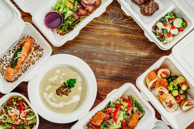 Group order of takeout food with many different meals in styrofoam containers