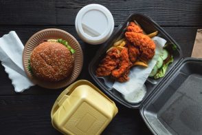 Takeout food including burger, chicken tenders, fries, and drink