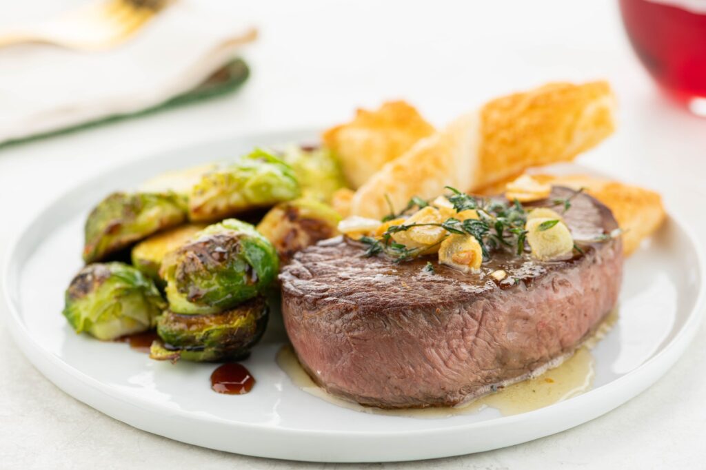 Photograph of a prepared meal of steak, brussel sprouts and steak fries from Home Chef.