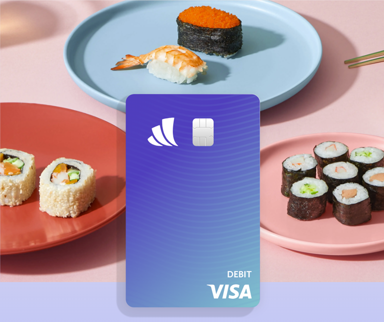 debit card from Wealthfront used on a background of a sushi dinner out