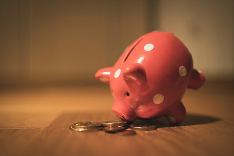 pink pig coin bank on brown wooden table; 401(k) hardship withdrawals