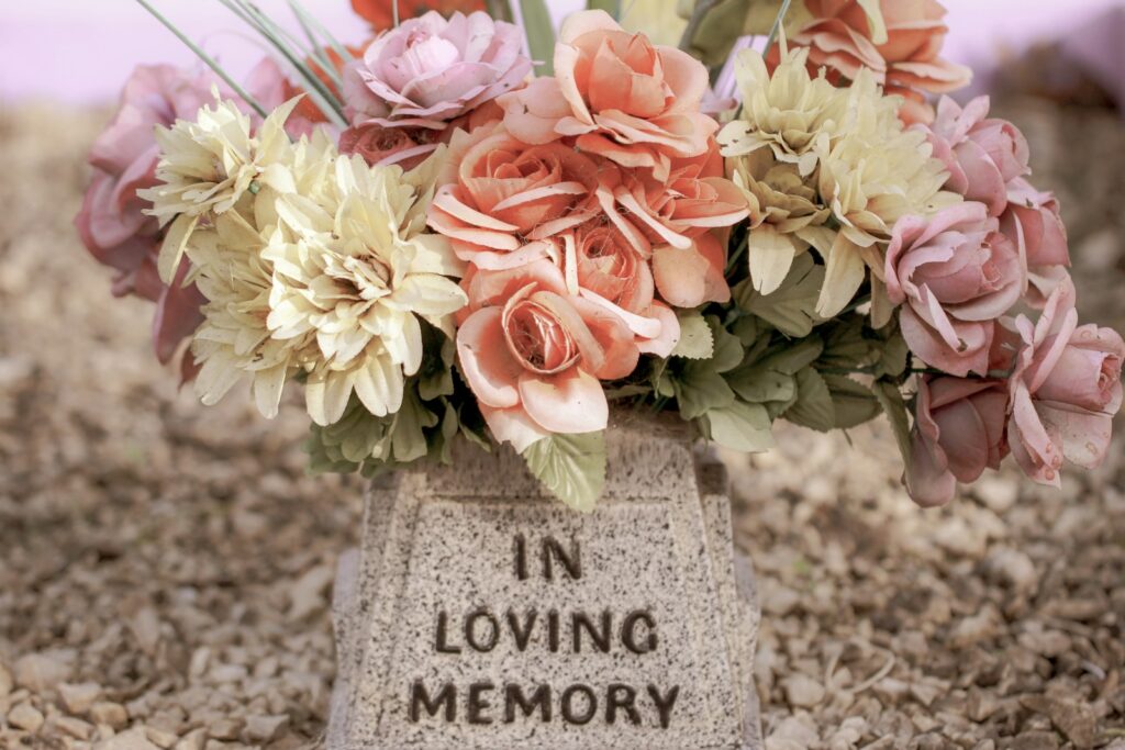 pink and white flowers on gray concrete tomb; affordable memorial ideas
