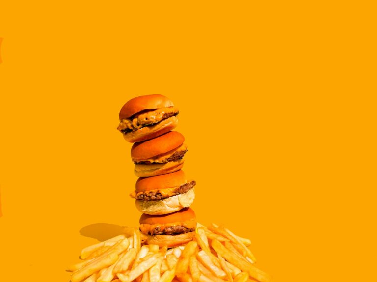 a stack of hamburgers and french fries on a yellow background; free food apps