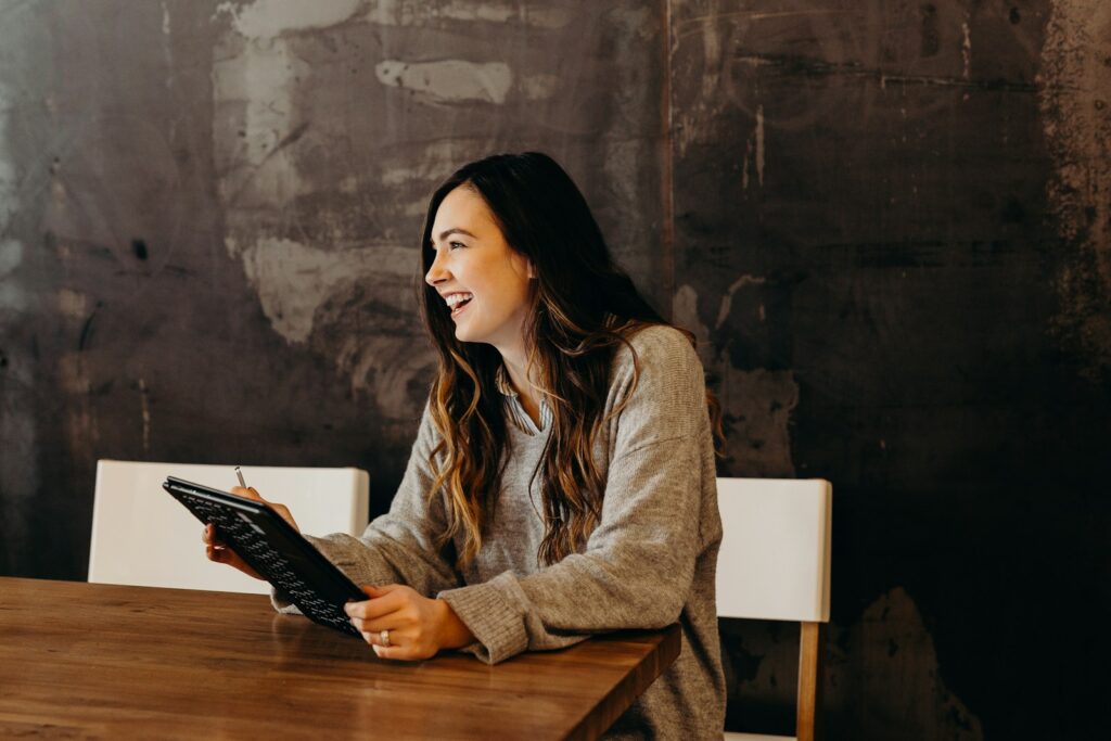 woman sitting around table holding tablet; financial upgrade
