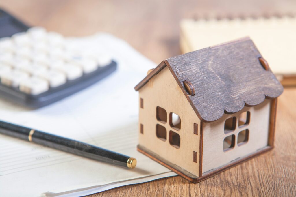 Model house with calculator and pen on desk.; personal credit for business loans