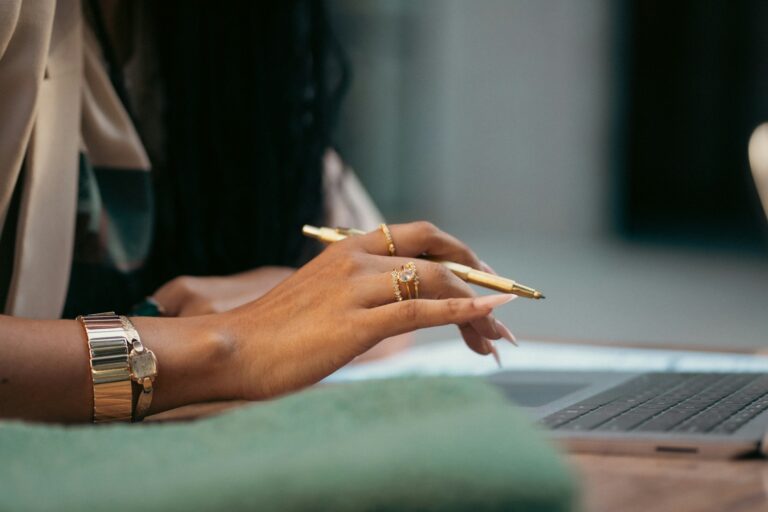 A woman sitting at a table with a laptop computer; business plan examples