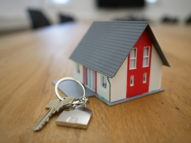white and red wooden house miniature on brown table; co-buying a home