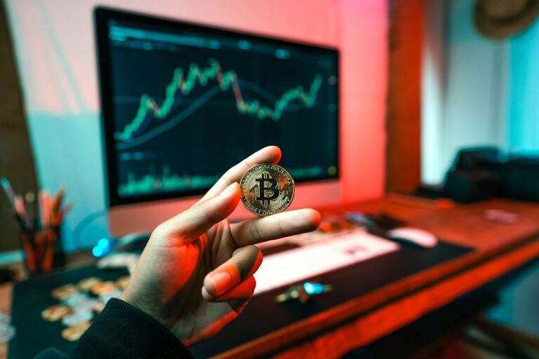 a person holding a coin in front of a computer; OTC crypto trading