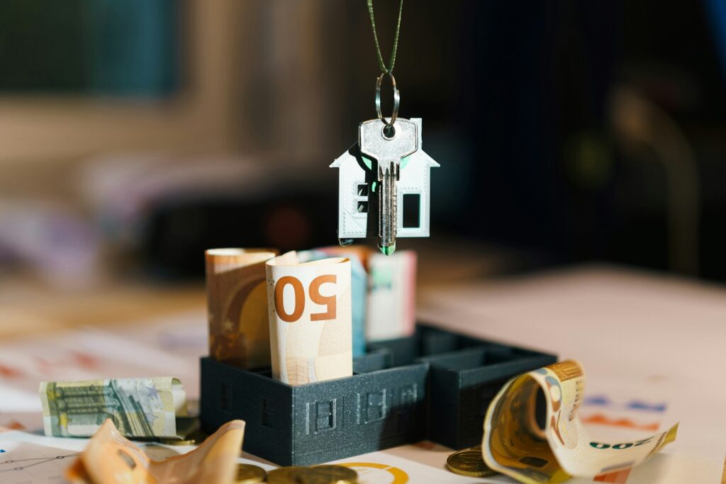 A house hanging from a string on top of a pile of money; How to Get the Most Money When Selling Your Home