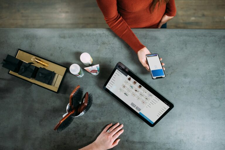 person holding smartphone beside tablet computer; AI customer experience