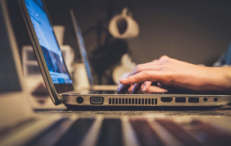 person using silver laptop computer on desk; internet in rural areas